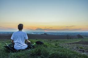 young man Meditating in countryside