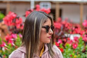 portrait of a girl with glasses on a background of red flowers