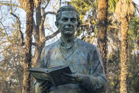 statue of a writer with a book in the park