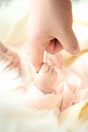mom holds baby by the hand