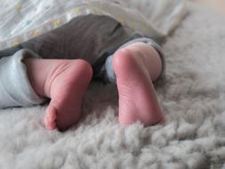 feet of a newborn under the covers