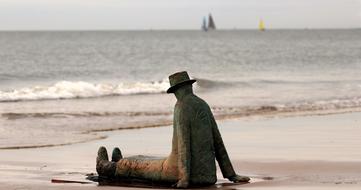 sitting man sculpture on beach at sea, Belgium, knokke