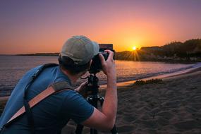 photographer takes a picture of the evening sun on the horizon