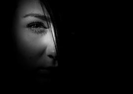 black and white photo of the girlâs half face covered in a dark