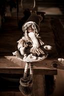 monochrome photo of a doll on a wooden table