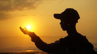 rising sun in the hand of a young man