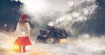 Girl with the lantern going to the house on the beautiful foggy landscape in winter