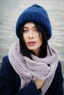 Brunette Girl in blue knitted hat posing at Sea
