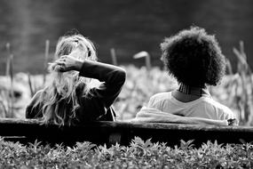 black and white photo of two girlfriends on a bench