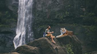 man and tiger on rock at waterfall, collage