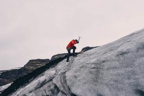 Mountain climber with the ice axe, on the beautiful icy mountain