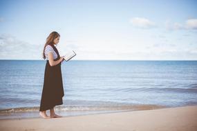 the girl with the Bible walks on the beach