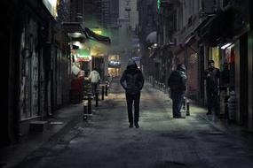 a man walks down a dark street