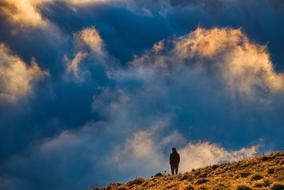 man on the mountain against the background of clouds