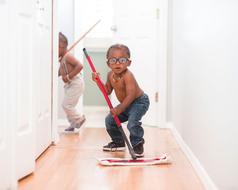 Boys in glasses, mopping the floor in the house