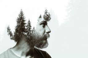 Black and white profile portrait of the bearded man, with the beautiful trees in the head
