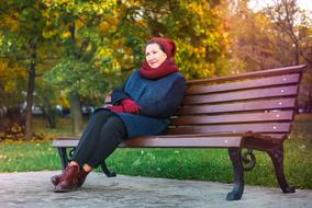 photo of woman in autumn clothes on a bench