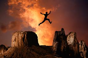 a young man in free flight over the rocks