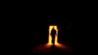 silhouette of a man against a background of bright door light