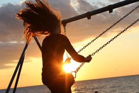 Girl on swing at Sunlight Sunset