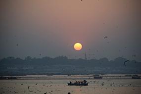 people in rowing boat on water at Sunset