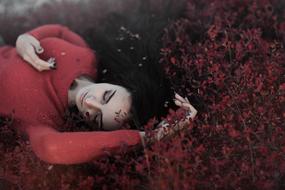 photo of a sleeping girl in a red sweater on the nature
