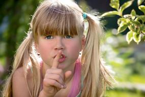 funny Child girl with finger at lips