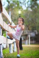 cute girl climbing to a fence