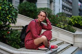 photo of a student in a burgundy plaid suit sitting on the steps