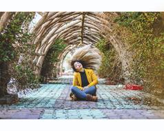 girl waving hair in a flower tunnel