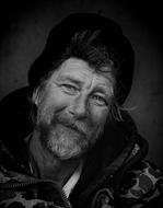 black and white photo of a homeless man in a black hat