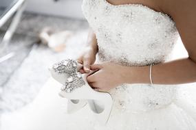 girl holds Wedding shoes at white dress, Bride