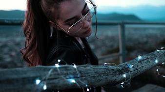 photo of a girl with glasses looking at a garland