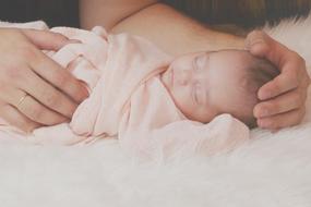 newborn Baby sleeps in male hands
