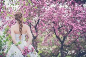 bride on a background of purple blooming tree