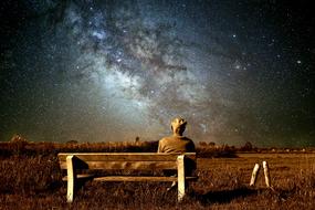 old man on bench at fantasy landscape