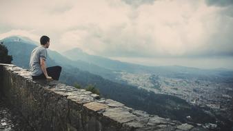 Person sitting on the wall on beautiful landscape with beautiful nature