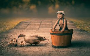 child in a wooden barrel and ducks
