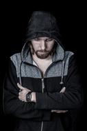 Portrait of the bearded man in black hood, at black background