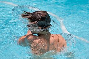 boy is splashing in the pool
