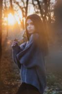 Portrait of the beautiful girl, among the colorful trees in the forest, at colorful sunset