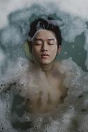 young asian man Bathing in foamy Water