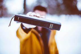 holy bible book in male hand