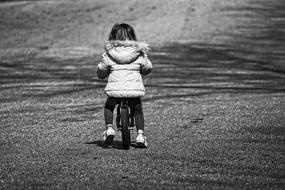 Little Child Girl riding away bicycle on road