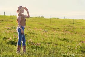 girl in cowboy clothes on a green field