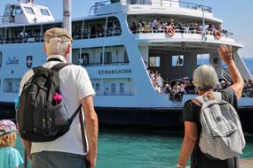 senior persons greeting people on tourist ship