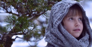 girl with a gray scarf on a background of a winter landscape with the plants