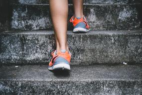 girl in sneakers goes up the stairs