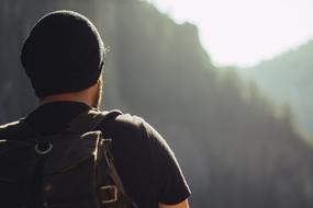 back of man in front of blurred Mountains