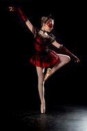 ballerina in a red-black dress on stage